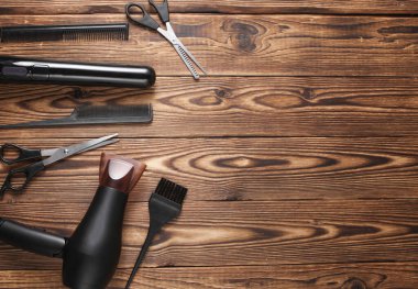 Düz yatıyordu kuaförlük aletleri ve aksesuarlar ahşap arka planda saç şekillendirme için. Üst görünüm