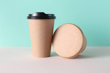 Çevre kartonundan yiyecek kutusu ve sıcak içecek bardağı, nane yeşili arka plan.