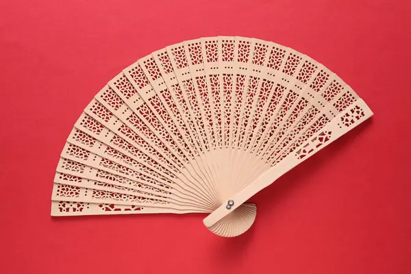 Kırmızı arka planda geleneksel Asyalı el vantilatörü.
