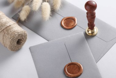 Balmumu mühürler, eski pullar, iplik yumağı, gri arka planda laguri çiçekleri. DIY, Hediye çeki, düğün davetiyesi.