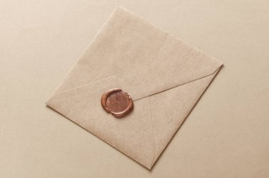 Bej arka planda balmumu mühürlü el işi zarf. Hediye çeki, düğün davetiyesi.