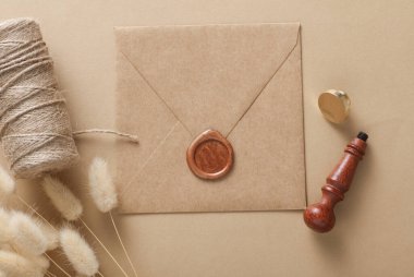 Balmumu mühürlü ve eski pullu el işi zarflar, iplik yumağı, bej arka planda laguri çiçekleri. DIY, Hediye çeki, düğün davetiyesi.