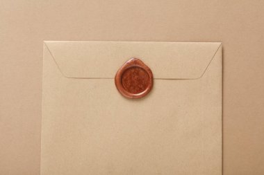 Bej arka planda balmumu mühürlü el işi zarf. Hediye çeki, düğün davetiyesi.