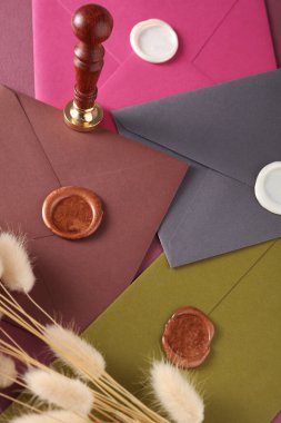 Renkli zarflar, balmumu mühür ve eski pul, lagurus çiçekleri. Hediye çeki, düğün davetiyesi.