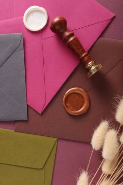 Renkli zarflar, balmumu mühür ve eski pul, lagurus çiçekleri. Hediye çeki, düğün davetiyesi.