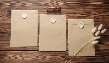 Balmumu mühürler, eski pullar, ahşap arka planda kuru çiçekler. Hediye çeki, düğün davetiyesi.