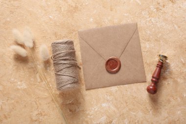 Balmumu mühürlü zarf, eski pul, iplik, çimento arka planda kuru çiçekler. DIY, Hediye çeki, düğün davetiyesi.