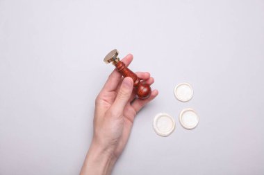 Gri arkaplanda klasik bir şahsi damgayı tutan kadın.