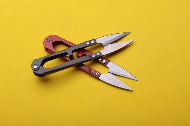 Sarı arka planda balık tutmak veya makas dikmek