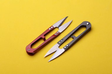 Sarı arka planda balık tutmak veya makas dikmek