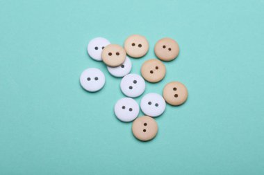 Nane yeşili arkaplanda beyaz ve tahta düğmeler