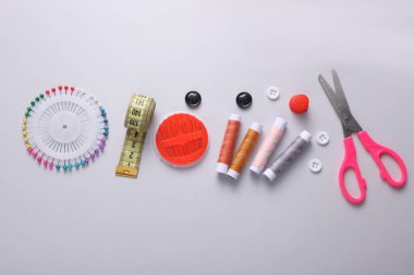 Gri arkaplanda terzi dikiş aksesuarları.