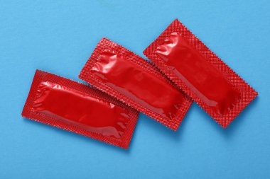 Mavi arkaplanda prezervatif paketleri