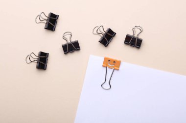 Gülümseyen yüz kablosuz kağıt tabaka ve bej arkaplanda yüzsüz klasörler. Liderlik, eşsizlik, kariyer gelişimi. İş konsepti.