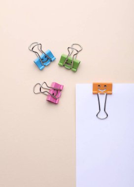 Gülümseyen yüzlü ataçlar ve bej arka planda kağıt kağıtlar. İş konsepti