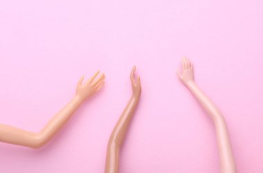 Pembe arka planda bir sürü farklı bebek eli var. Sosyal destek, arkadaşlık, toplum