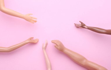 Pembe arka planda bir sürü farklı bebek eli var. Sosyal destek, arkadaşlık, toplum