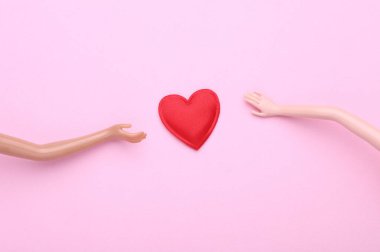 Bebeklerin elleri ve pembe arka planda bir kalp. Aşk konsepti