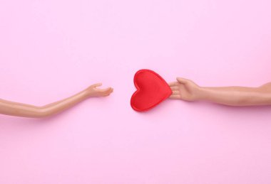 Bebeklerin elleri ve pembe arka planda bir kalp. Aşk konsepti