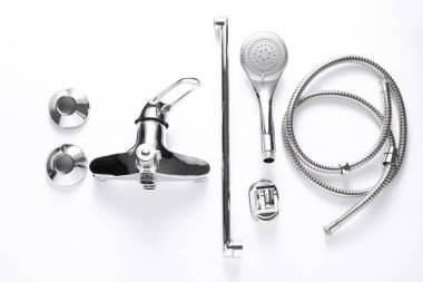 Parçalanmış küvet musluğunun beyaz arka planda duş alan parçaları.