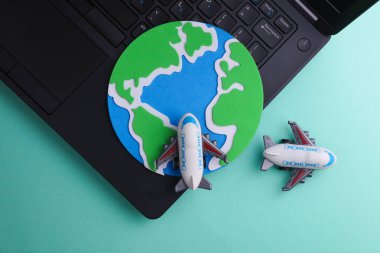 Mavi arka planda dizüstü bilgisayarı olan uçak modeli. Seyahat kavramı