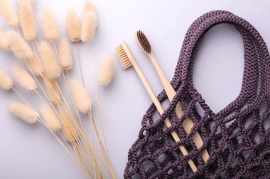 Gri arka planda diş fırçası olan bir eko torba. Yukarıdan görüntüle