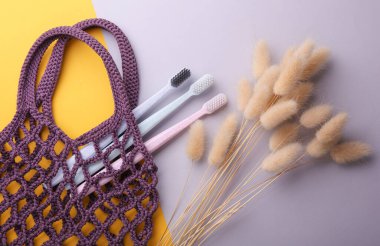 Gri arka planda diş fırçası olan bir eko torba. Yukarıdan görüntüle