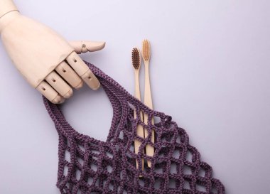 Gri arka planda diş fırçası olan bir eko torba. Yukarıdan görüntüle