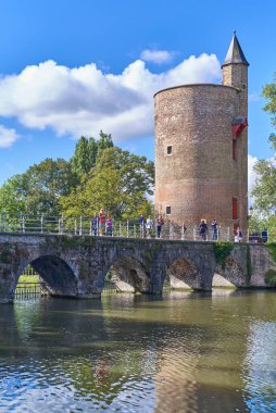 Bruges, Belçika - 7 Eylül 2018: Minnewatwr kanalı üzerinde arka planda Toz Kulesi olan turistler