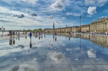 Bordeaux, France - August 17, 2019: Tourists in the famous Water Mirror in the Stock Exchange square area