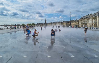 Bordeaux, France - August 17, 2019: Tourists in the famous Water Mirror in the Stock Exchange square area