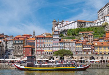 Porto, Portekiz - 17 Nisan 2023: Ribeira bölgesinin mimarisi ve Douro Nehri 'nden görülen turistler için bir tekne