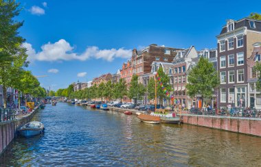 Amsterdam, Hollanda - 12 Ağustos 2023. Eski kasabadaki kanal kıyısında geleneksel tarz evler