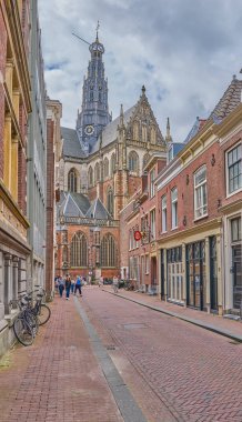Haarlem, Hollanda - 13 Ağustos 2023: St. Bavo Kilisesi (Grote Kerk) eski şehrin bir caddesinde görüldü