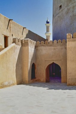 Umman Sultanı Nizwa, 17. yüzyıl güçlendirilmiş kalesi. Arka planda Sultan Qaboos Camii 'nin minaresi var.