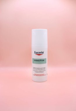 KYIV, UKRAINE - 1 Temmuz 2023: Beyaz Almanya Eucerin kozmetik şişesi. Eucerin Derisi Saf Cilt İlavesi Rahatlatıcı Krem. Sağlıklı cilt için cilt bakımı ürünü. Pembe arka planda izole edilmiş.