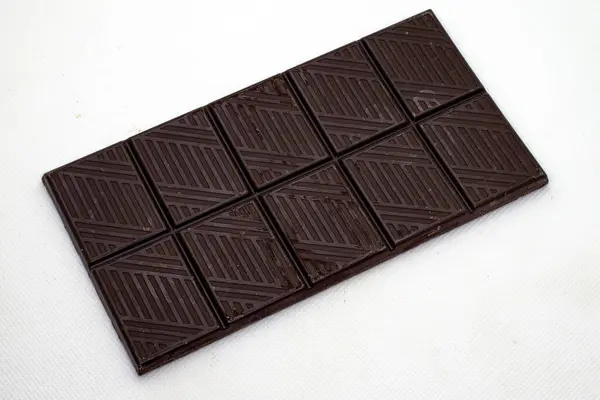 stock image A bar of dark chocolate cropped against white background