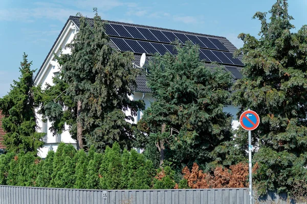 Rising electricity costs and self-production of electricity, house roof with photovoltaic elements