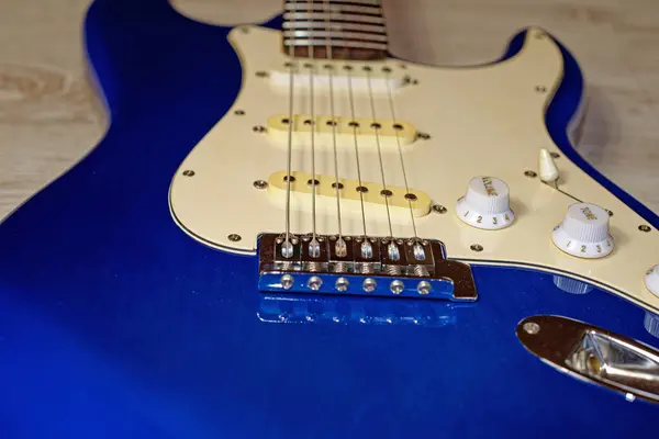 Music, pop, rock: blue electric guitar, Stratocaster shape, close-up of bridge, strings and controls
