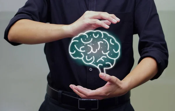 Man holding digital of human brain in his hand. Artificial intelligence and holographic concept.