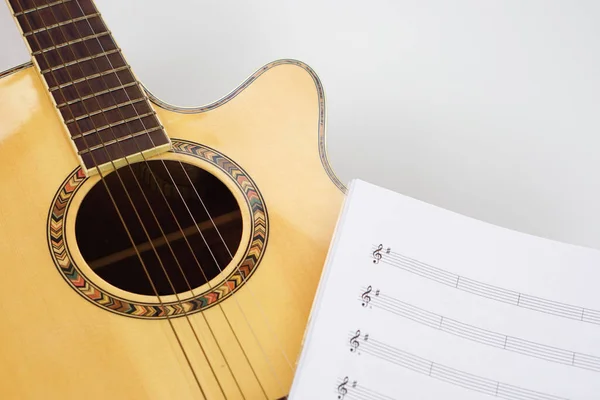 Acoustic guitar with music notes on white background. Love, music and learning concept.