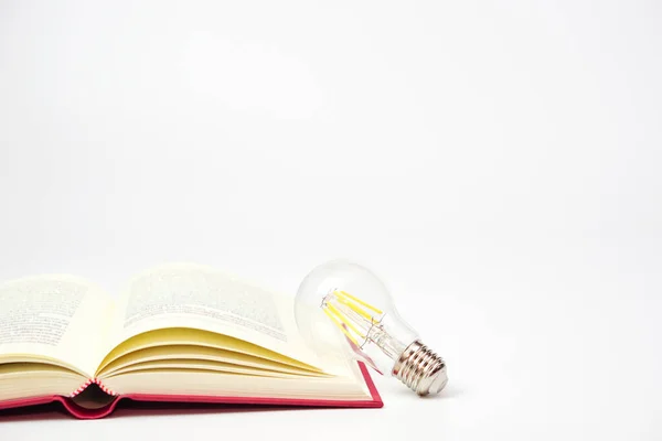 Лампочка Светится Книгой Белом Фоне Концепция Знаний Мудрости Новых Идей — стоковое фото