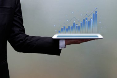 Sanal dijital grafik büyümesini gösteren bir tablet. Ekonomik yatırım eğilimleri, hologram ticareti parlama ve gelecekteki teknoloji.