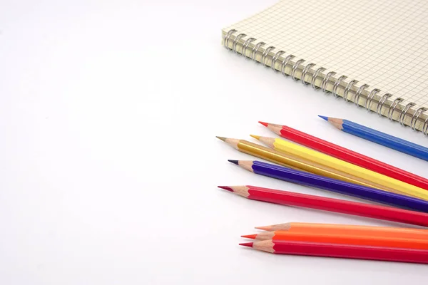 Renkli kalemlerin ya da pastelin odak noktası hizalandı ve beyaz arkaplan üzerine bulanık grafik kitabı. Öğrenme, öğrenme ve sunum kavramı.