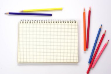 Grafik kitabı ve bulanık renkli kalemler ya da beyaz zemin üzerine dizilmiş pastel. Öğrenme, öğrenme ve sunum kavramı.