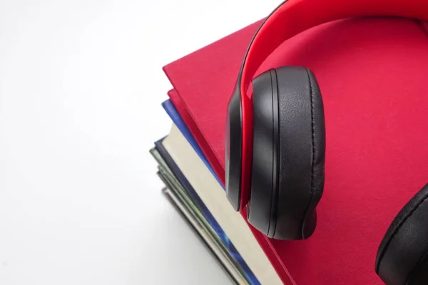 stock image Focus of headphones are on stack of books. Modern education and relaxation concept.