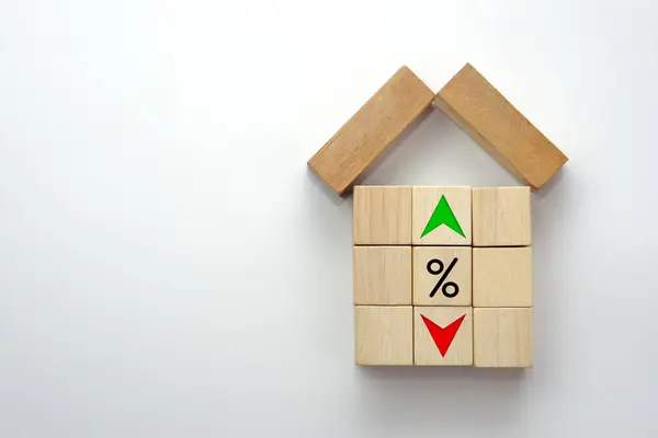 House shape made by wooden block with percentage on wooden block and up and down of arrow. Interest rate finance, real estate and house loan concept.