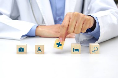 Hand holding a wooden block cube with healthcare medical icon symbol. Medical and health concept.