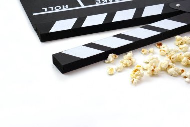 Alkış tahtası ya da film kaplaması beyaz arka planda patlamış mısırlı siyah renkli. Sinema endüstrisi, video üretimi ve film konsepti.