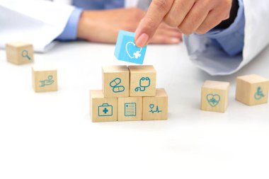 Hand holding a wooden block cube the top one with heart rate icon symbol. Medical and health concept.